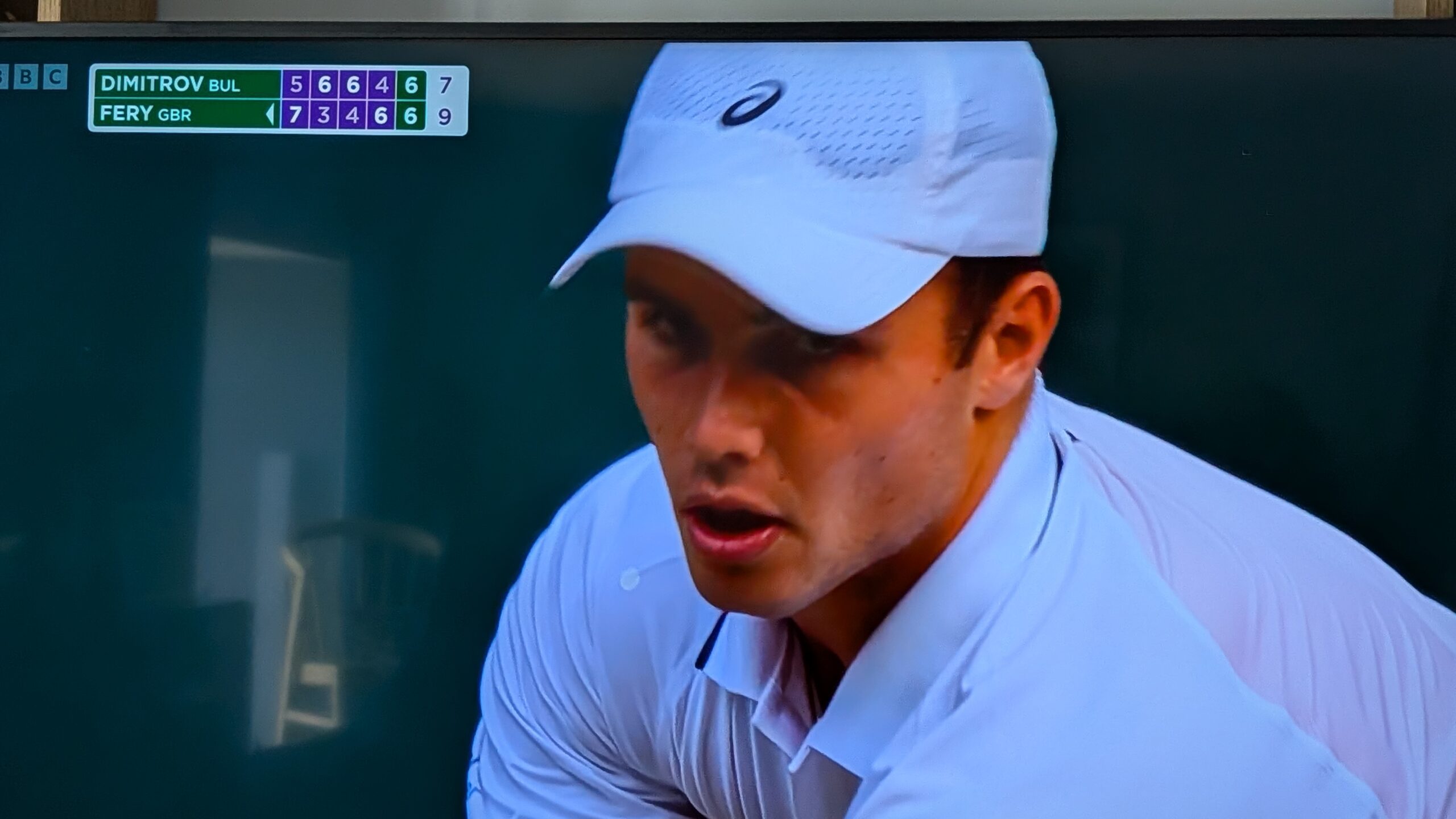 Photo of TV screen showing Arthur Fery about to serve for the match against Grigor Dimitrov at Wimbledon in July 2026